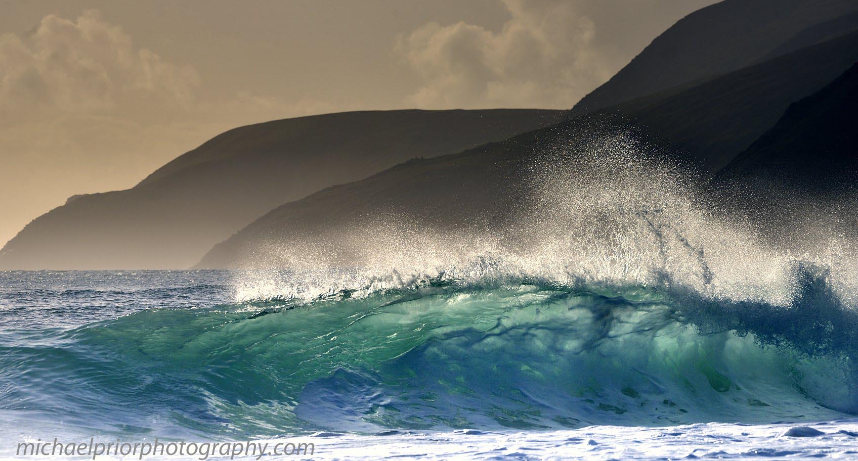 The Sun shining Through A Wave With The Blasket Islands In The Background.