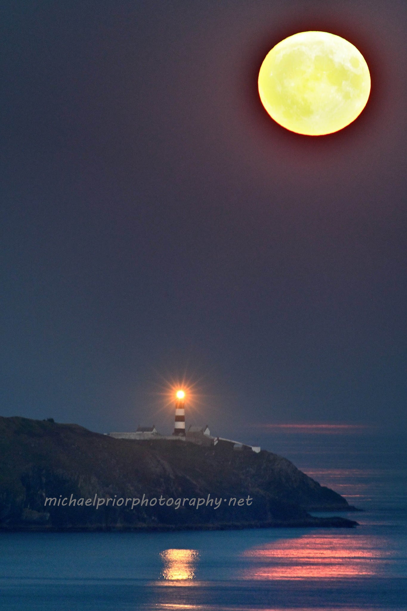 Full (sturgeon) moon rising over the Oldhead lighthouse in west Cork